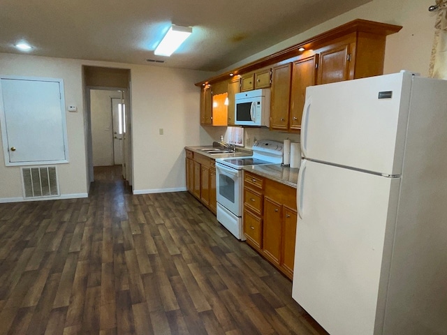 kitchen featuring white appliances, sink, and dark hardwood / wood-style floors