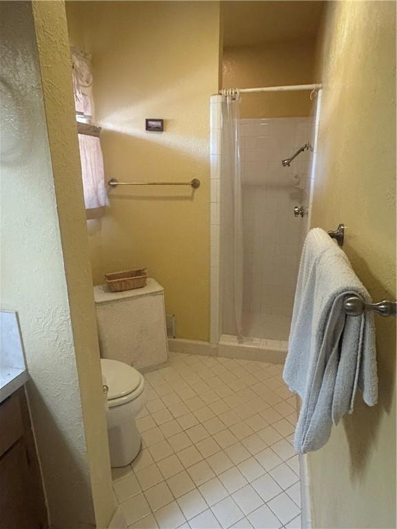 6026 Killarmet, Corpus Christi, TX 78413 - full bathroom featuring tile patterned floors, a shower stall, vanity, and toilet