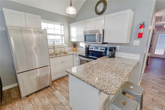 4601 Gulfbreeze Blvd Unit 1, 2, 3, 4, 5, Corpus Christi, TX 78402 - kitchen with white cabinets, hanging light fixtures, sink, appliances with stainless steel finishes, and kitchen peninsula