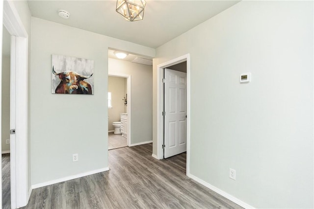 empty room with hardwood / wood-style floors and a notable chandelier