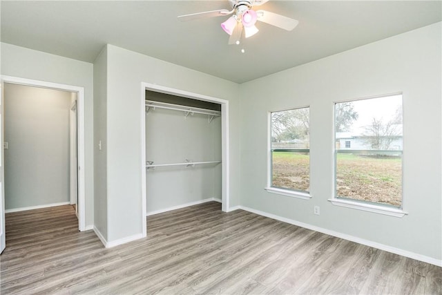 unfurnished bedroom with ceiling fan, a closet, and light wood-type flooring