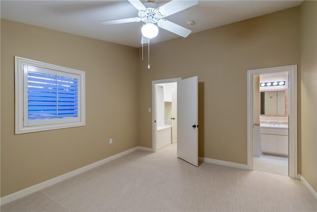 unfurnished bedroom featuring light carpet, ensuite bath, and ceiling fan