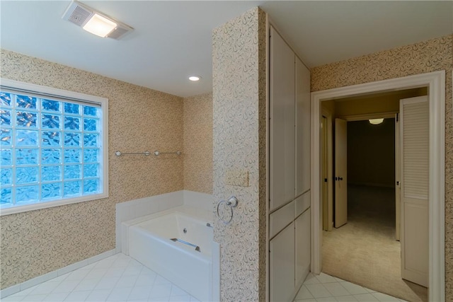 bathroom with a washtub and tile patterned floors