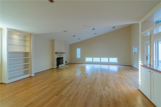 unfurnished living room with built in shelves, plenty of natural light, high vaulted ceiling, and light wood-type flooring