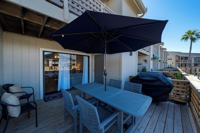 wooden terrace featuring outdoor dining space and grilling area