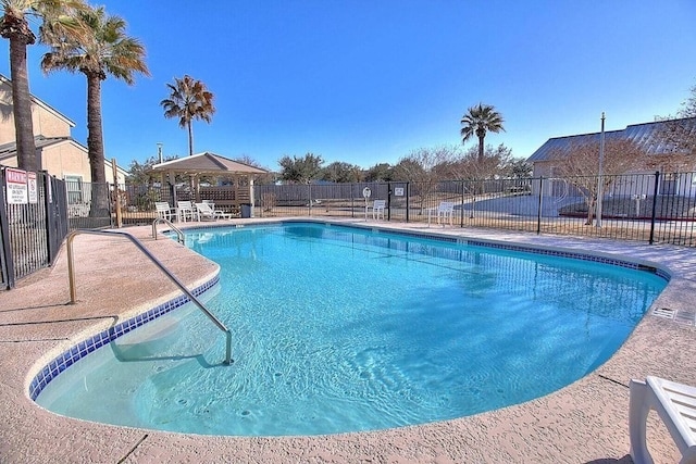 pool featuring fence and a patio area