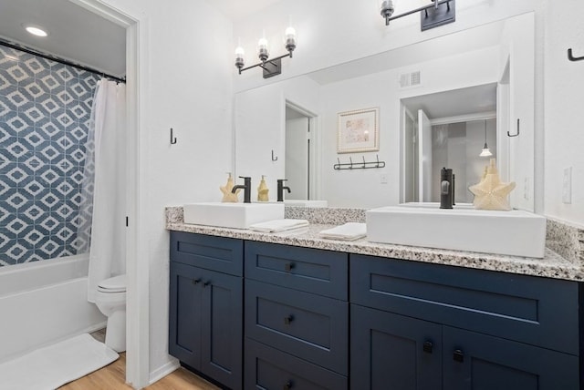 bathroom with visible vents, double vanity, and a sink
