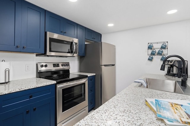 kitchen with blue cabinets, stainless steel appliances, recessed lighting, and a sink