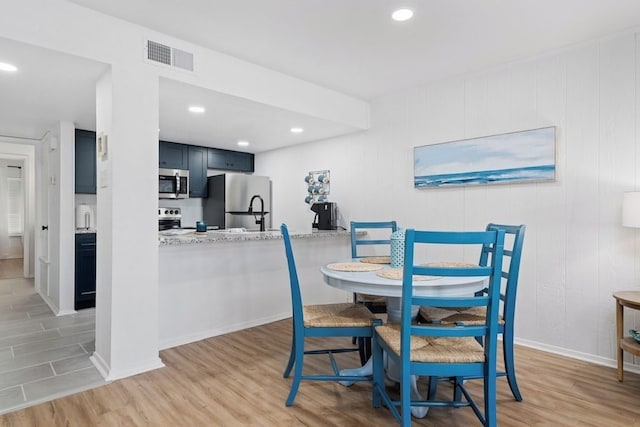 dining space with baseboards, visible vents, light wood-style floors, and recessed lighting