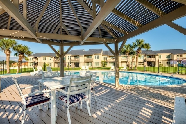 community pool with a deck, fence, and a residential view