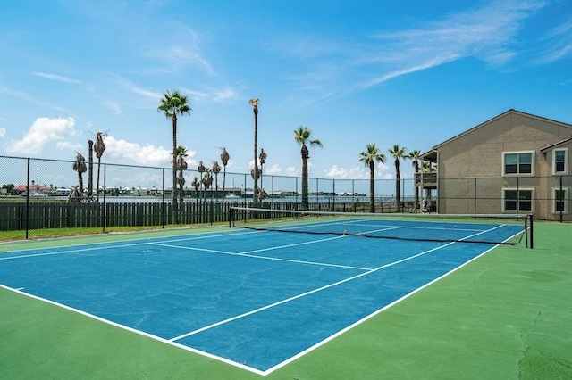 view of tennis court with community basketball court and fence