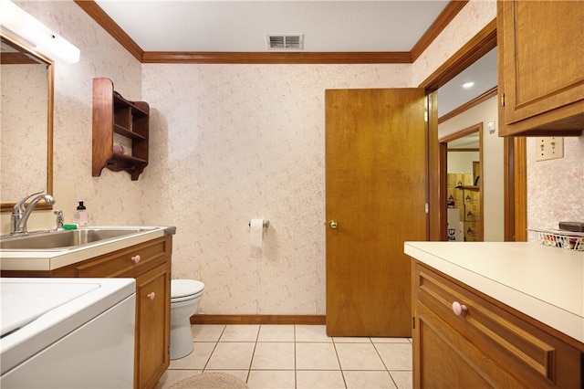 bathroom featuring sink, tile patterned flooring, washer / clothes dryer, toilet, and ornamental molding