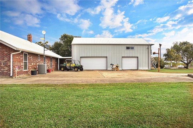 garage with a yard and central AC unit