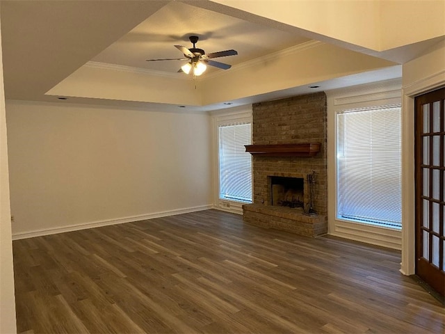 unfurnished living room with dark wood-type flooring, a fireplace, ceiling fan, and crown molding