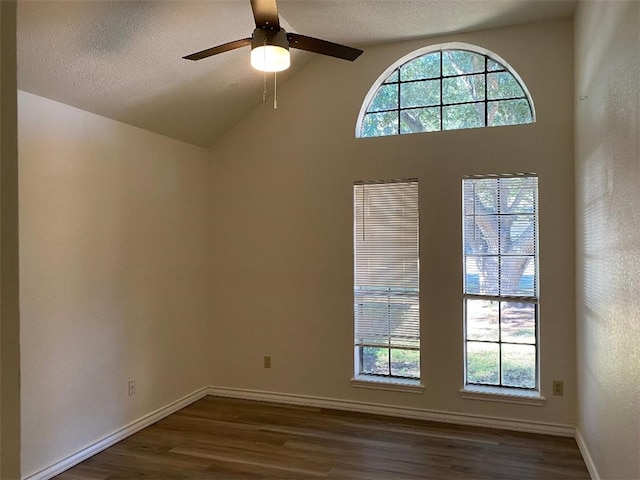 unfurnished room with dark wood-type flooring, vaulted ceiling with beams, and a healthy amount of sunlight