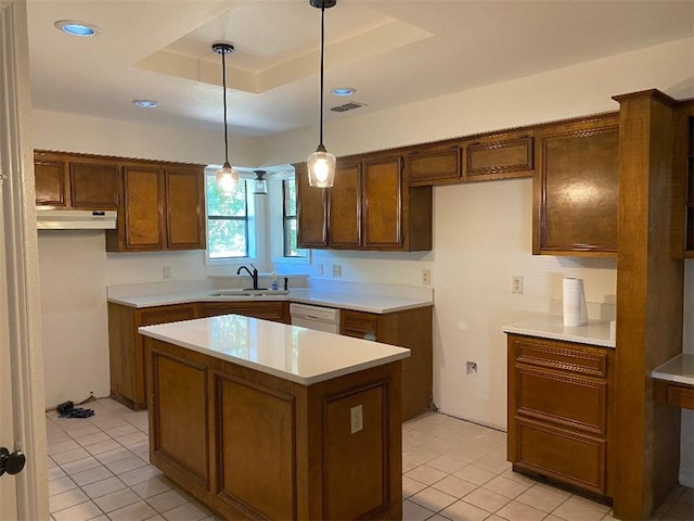 kitchen featuring white dishwasher, a raised ceiling, hanging light fixtures, sink, and a center island