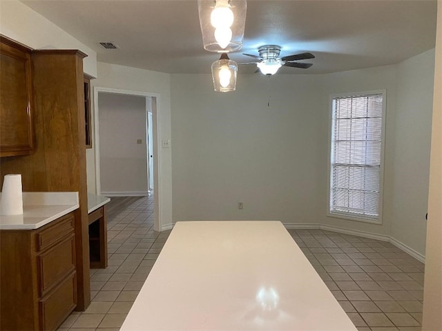 interior space with light tile patterned floors and ceiling fan