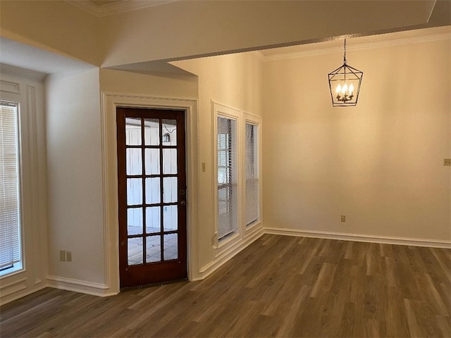 entryway with a wealth of natural light, dark hardwood / wood-style flooring, and crown molding