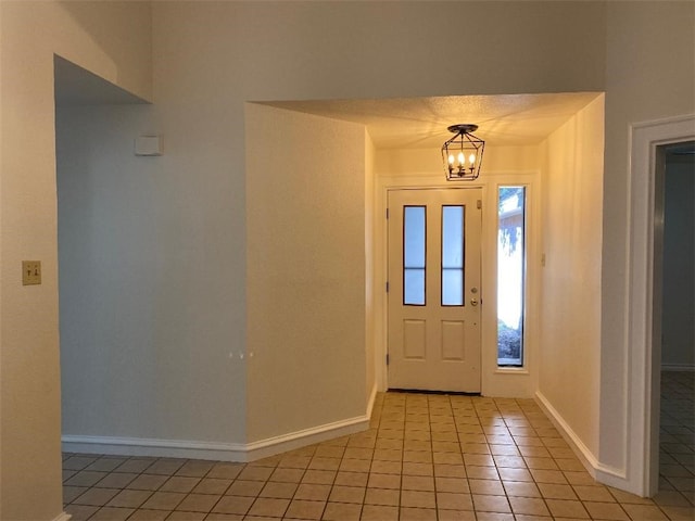 tiled foyer entrance featuring a chandelier