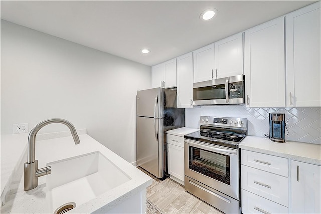 611 Lauderdale Dr, Rockport, TX 78382 - kitchen featuring stainless steel appliances, a sink, white cabinetry, backsplash, and recessed lighting