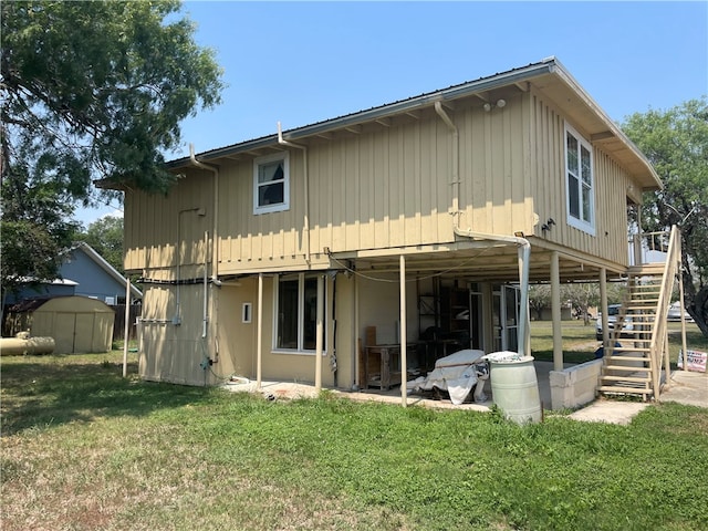 back of house featuring a yard and a storage unit