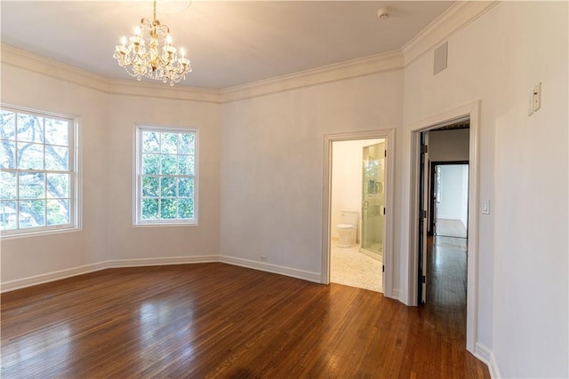 unfurnished room featuring an inviting chandelier, dark wood-type flooring, baseboards, and ornamental molding