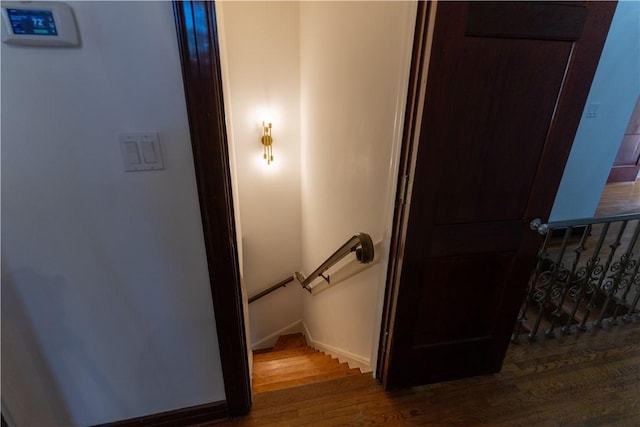 stairway featuring baseboards and wood finished floors