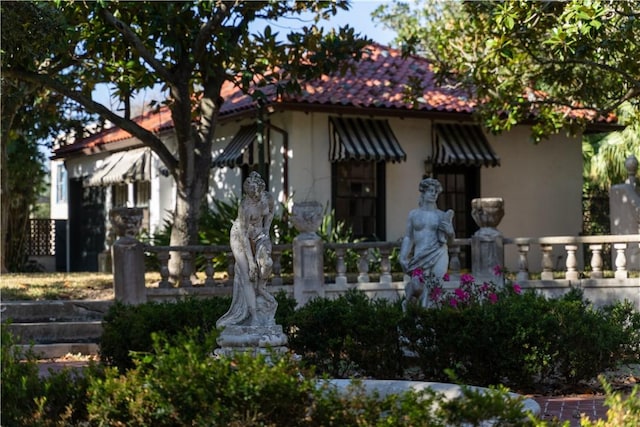 view of front of property featuring stucco siding and a tile roof