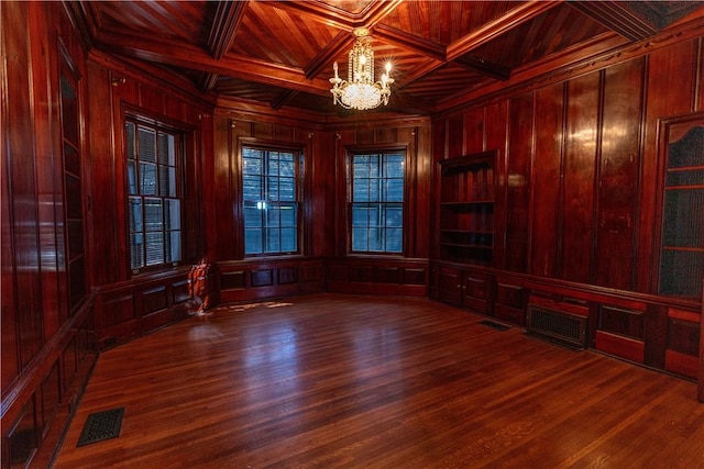 unfurnished room with a notable chandelier, visible vents, wood ceiling, and wooden walls