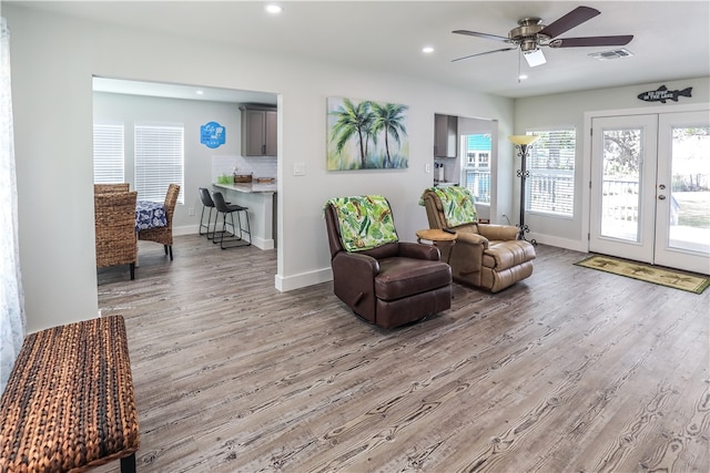 sitting room featuring french doors, ceiling fan, and light hardwood / wood-style flooring