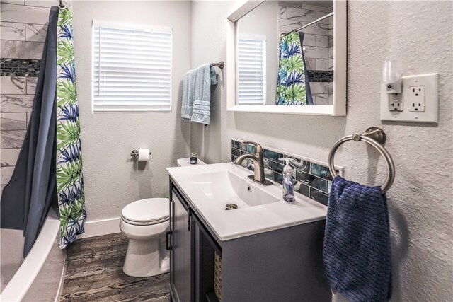 full bathroom featuring hardwood / wood-style floors, vanity, toilet, and shower / tub combo