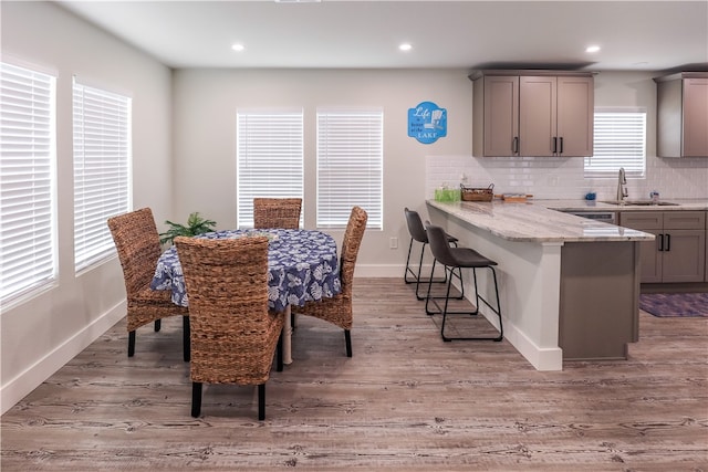 dining space with light hardwood / wood-style floors and sink