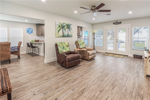 living area featuring french doors, light wood-type flooring, and ceiling fan