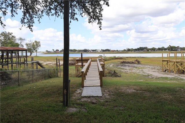 dock area with a yard and a water view