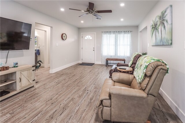 living room featuring ceiling fan and light hardwood / wood-style flooring