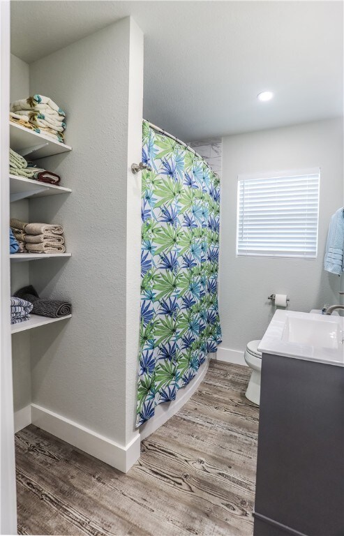 bathroom with vanity, hardwood / wood-style flooring, and toilet