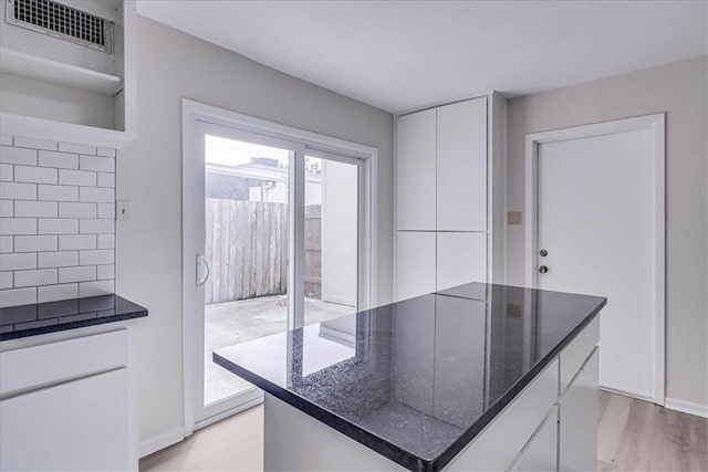 kitchen featuring open shelves, a kitchen island, visible vents, and white cabinets