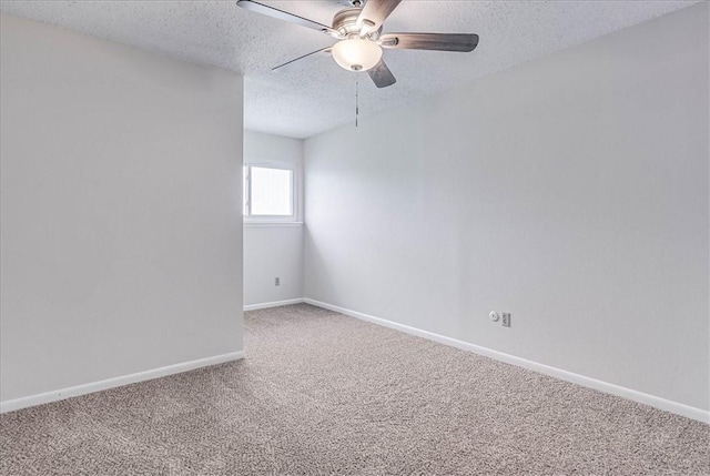 empty room with a ceiling fan, carpet, baseboards, and a textured ceiling