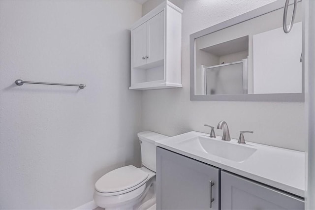 full bath featuring toilet, a stall shower, and vanity