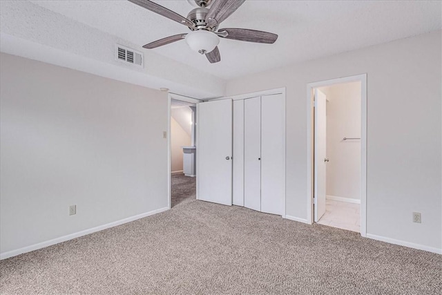 unfurnished bedroom featuring ensuite bathroom, light carpet, visible vents, baseboards, and a closet