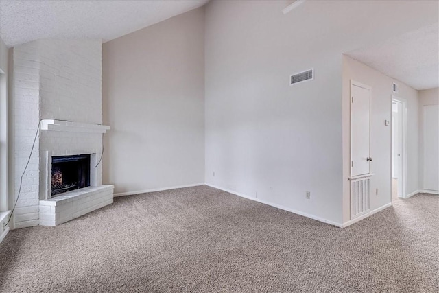 unfurnished living room featuring a brick fireplace, carpet, visible vents, and vaulted ceiling