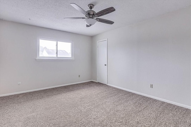 carpeted spare room featuring a textured ceiling, ceiling fan, and baseboards