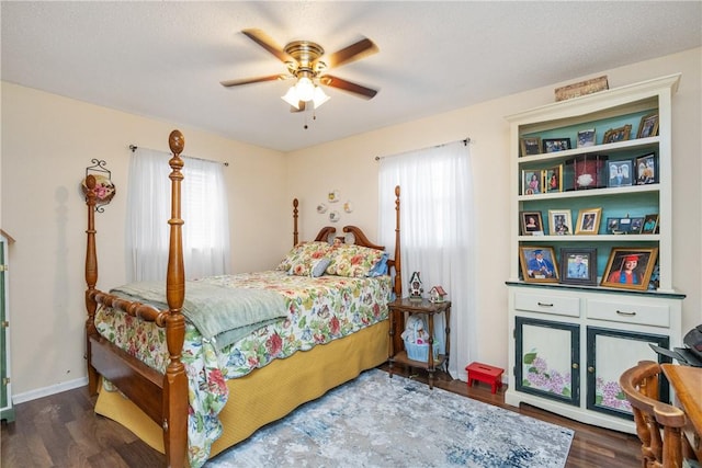 bedroom with a textured ceiling, ceiling fan, and dark wood-type flooring