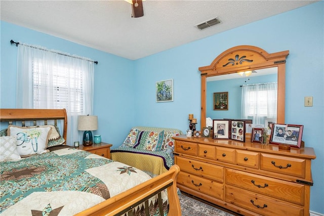 bedroom with ceiling fan and a textured ceiling