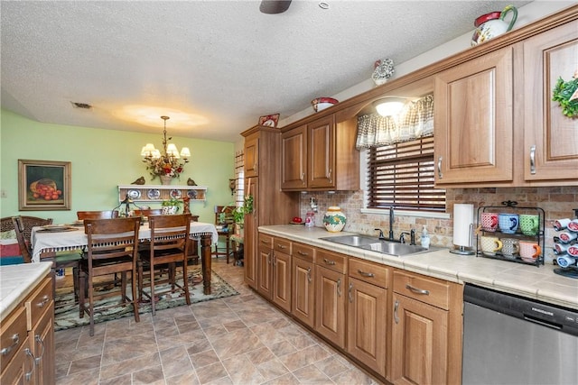 kitchen with tile countertops, dishwasher, sink, and a chandelier