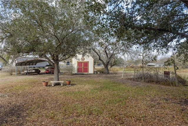 view of yard with a carport and a storage shed