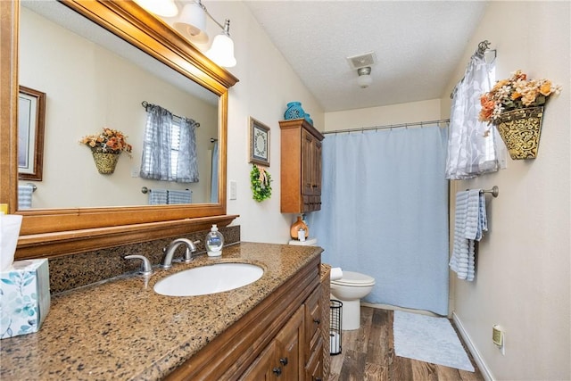 bathroom with hardwood / wood-style floors, vanity, a textured ceiling, and toilet