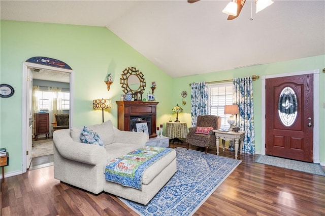 living room with ceiling fan, wood-type flooring, and vaulted ceiling