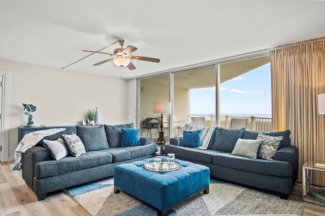 living room featuring ceiling fan and light hardwood / wood-style flooring