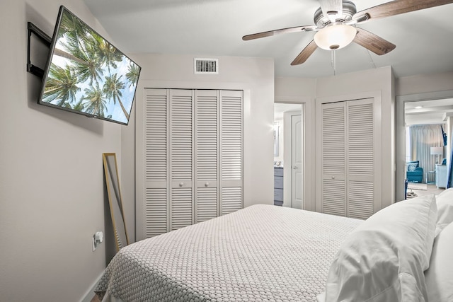 bedroom with ceiling fan and two closets